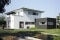 The picture shows a light, modern new building with a veranda.